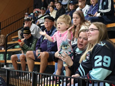 Photo of a child Kraken fan clapping in the stands at a Kraken practice.